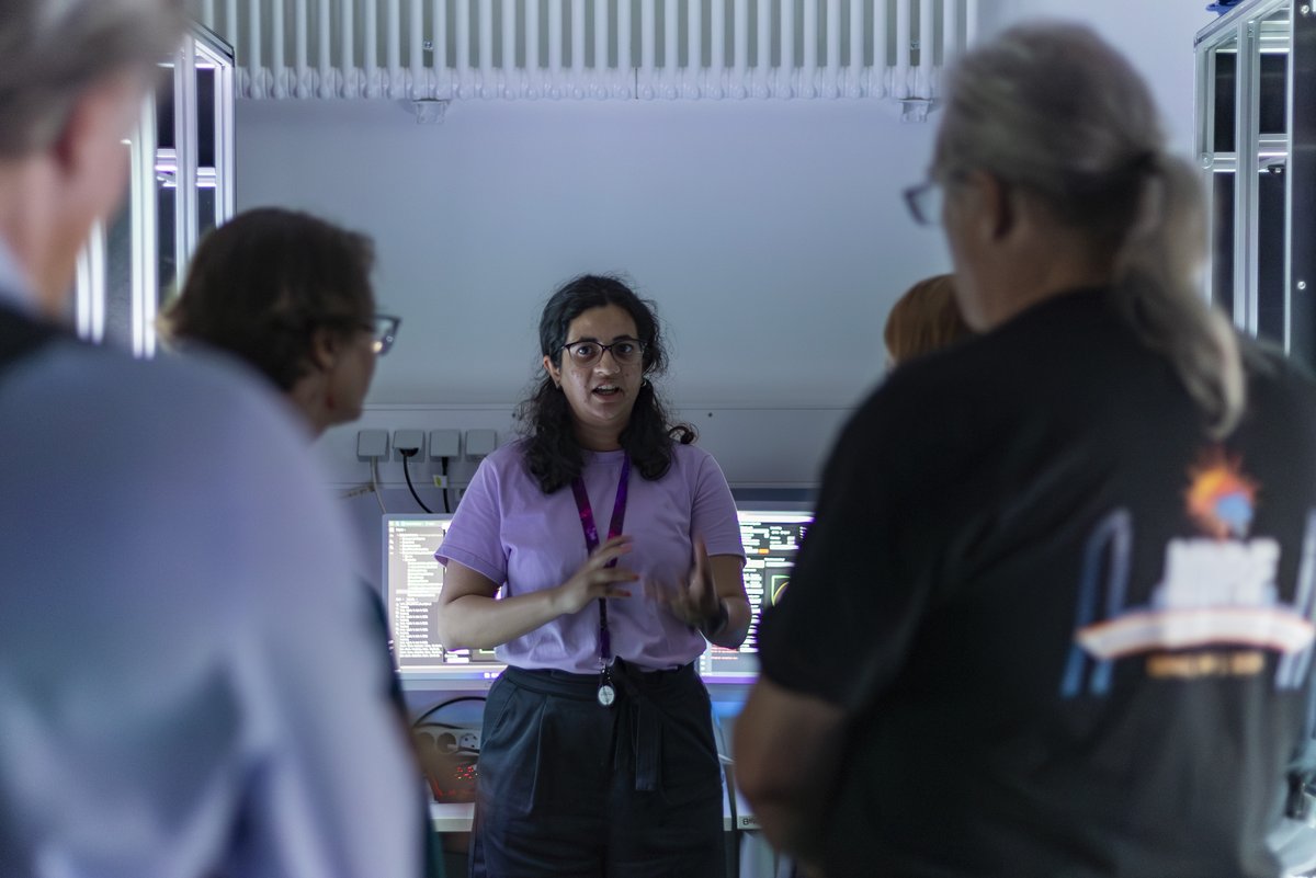 A woman talking explaining something to other researchers.